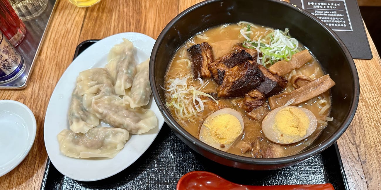 Tokijska zupa ramen z pierożkami gyoza i jajkiem na twardo, podana na tacy