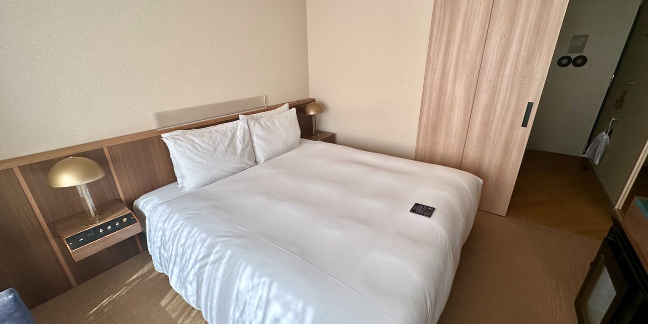 Pokój hotelowy w akihabarze, tokio, z dużym łóżkiem i drewnianą zabudową