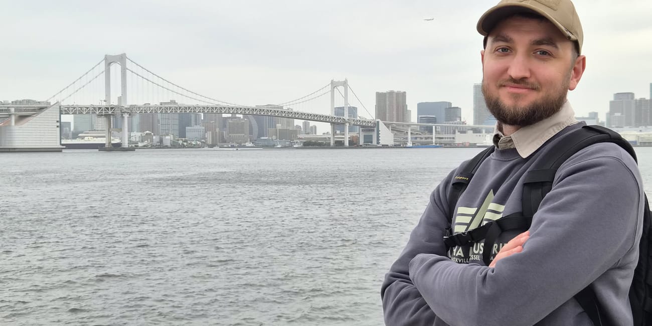 Mężczyzna na tle rainbow bridge w tokio, nad wodą