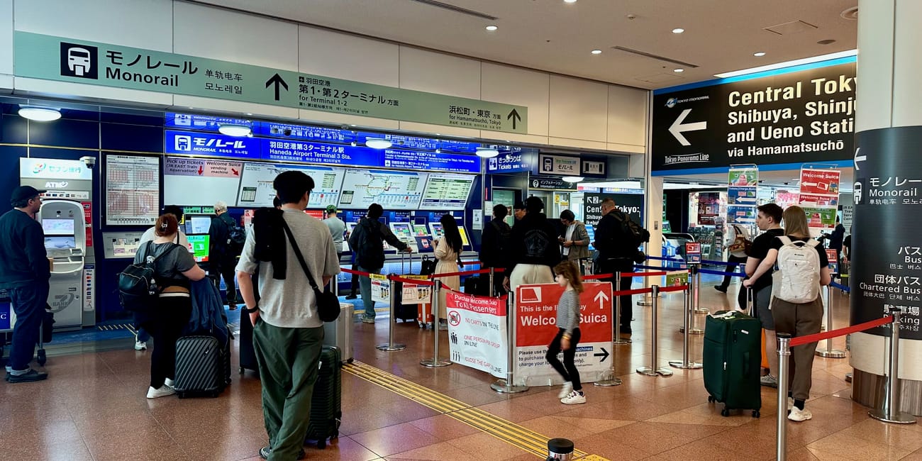 Kasa biletowa tokyo monorail na lotnisku haneda w tokio z kolejką pasażerów i tablicami informacyjnymi