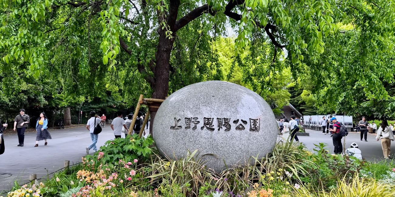 Wejście do parku ueno w tokio z kamiennym znakiem i kwiatami