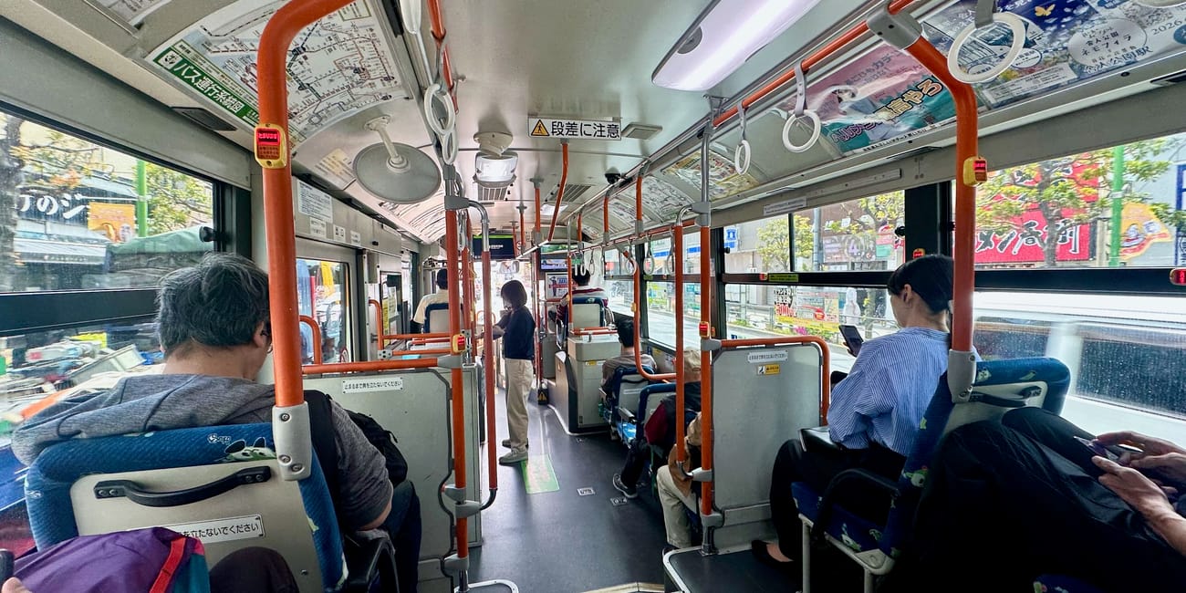 Wnętrze autobusu w japonii z pasażerami podczas jazdy przez miasto