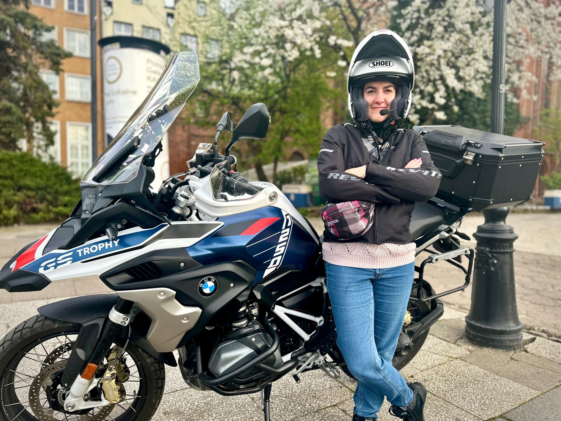 Kobieta w kasku stoi przy motocyklu bmw gs trophy w gdańsku.