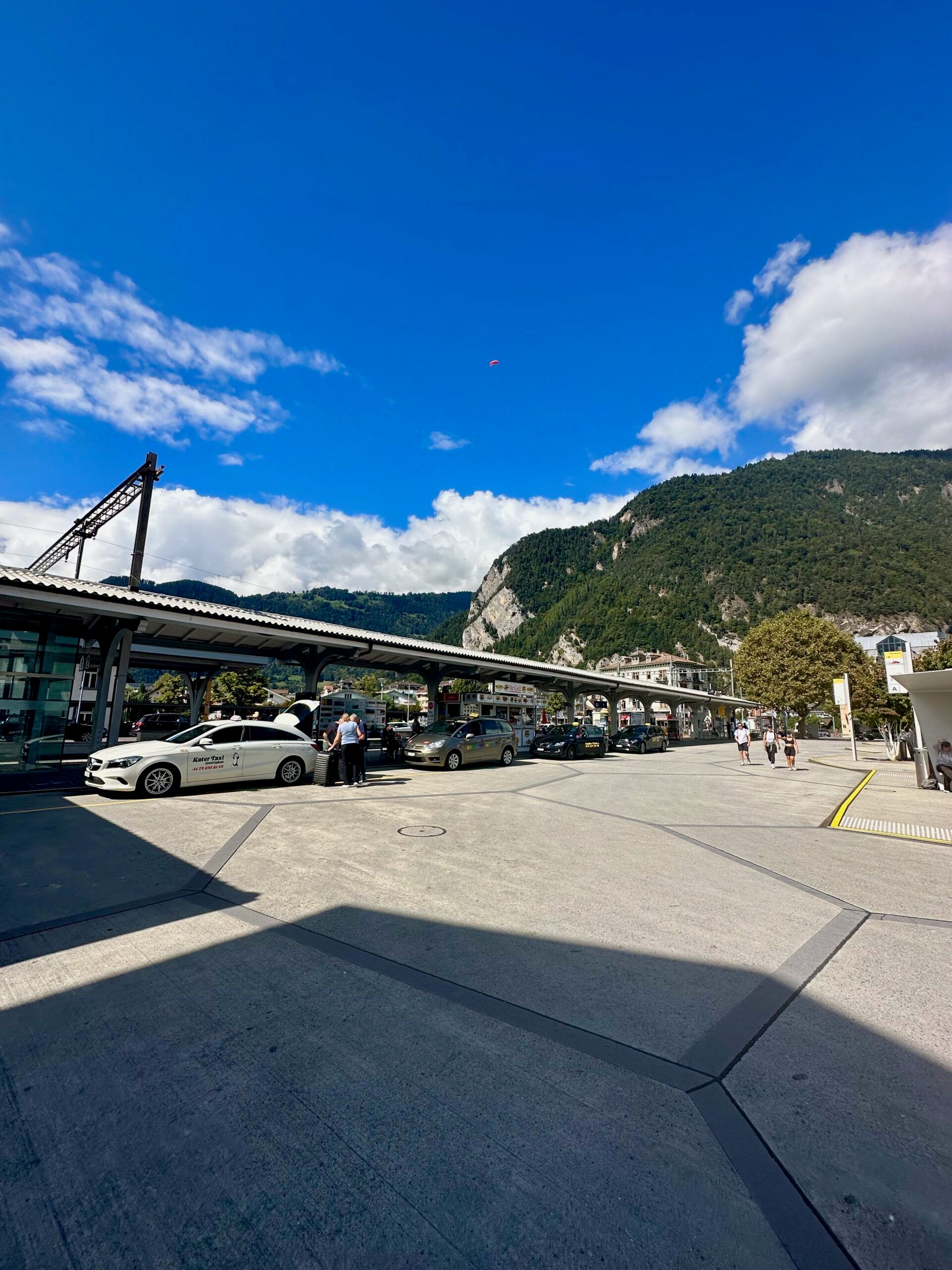Dworzec w interlaken z peronami, taksówkami i górami w tle pod błękitnym niebem