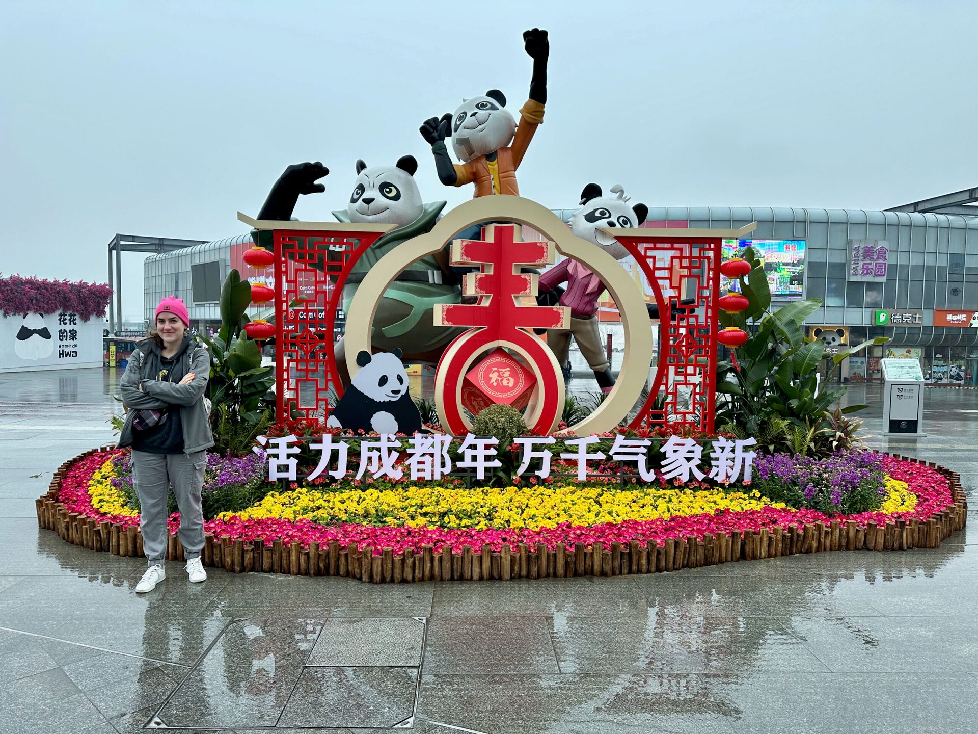 Dekoracyjna instalacja z pandami w chengdu, otoczona kwiatami i chińskimi lampionami.