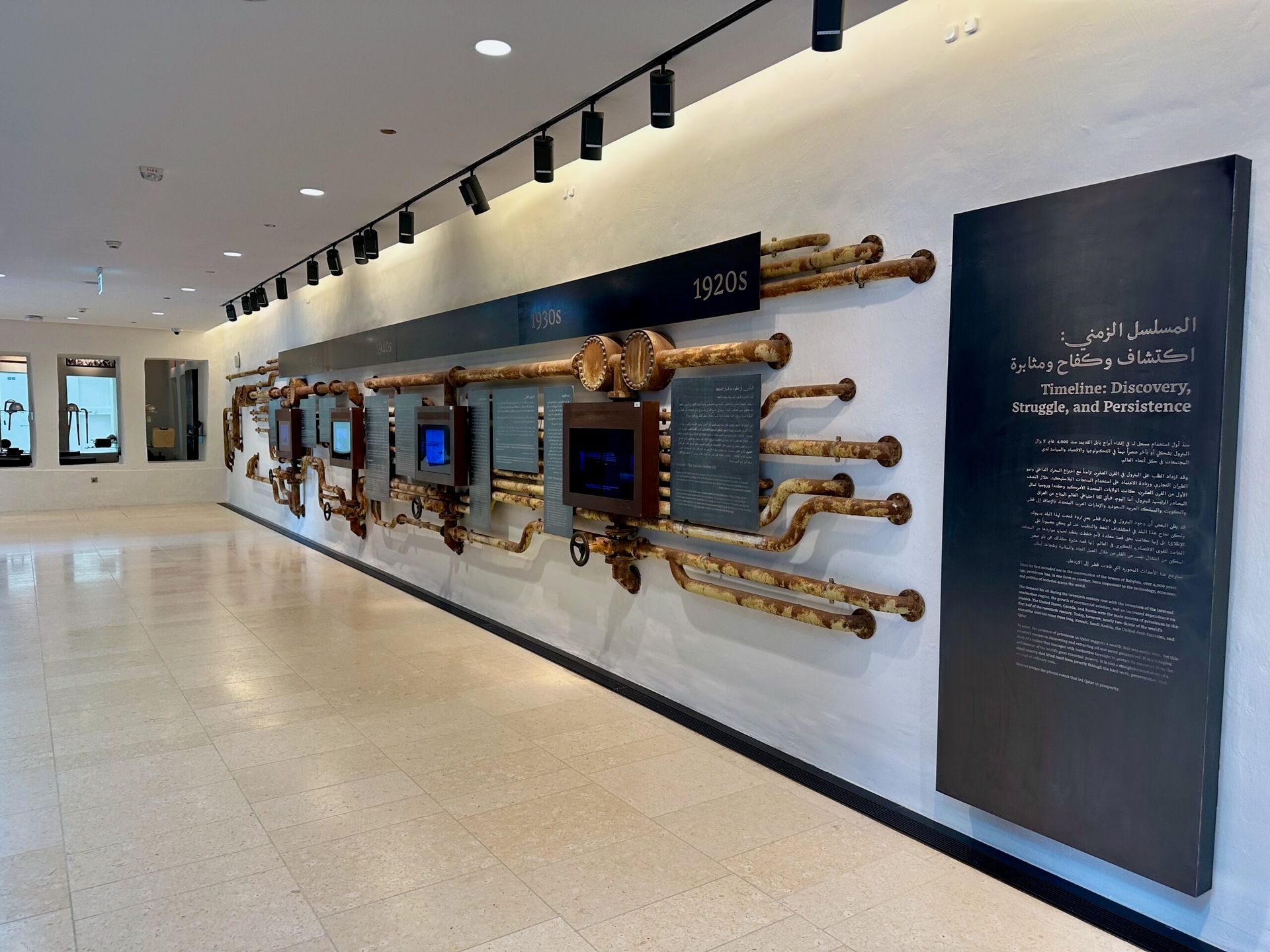 Wystawa w msheireb museums w doha z historyczną osią czasu i metalowymi instalacjami na ścianie