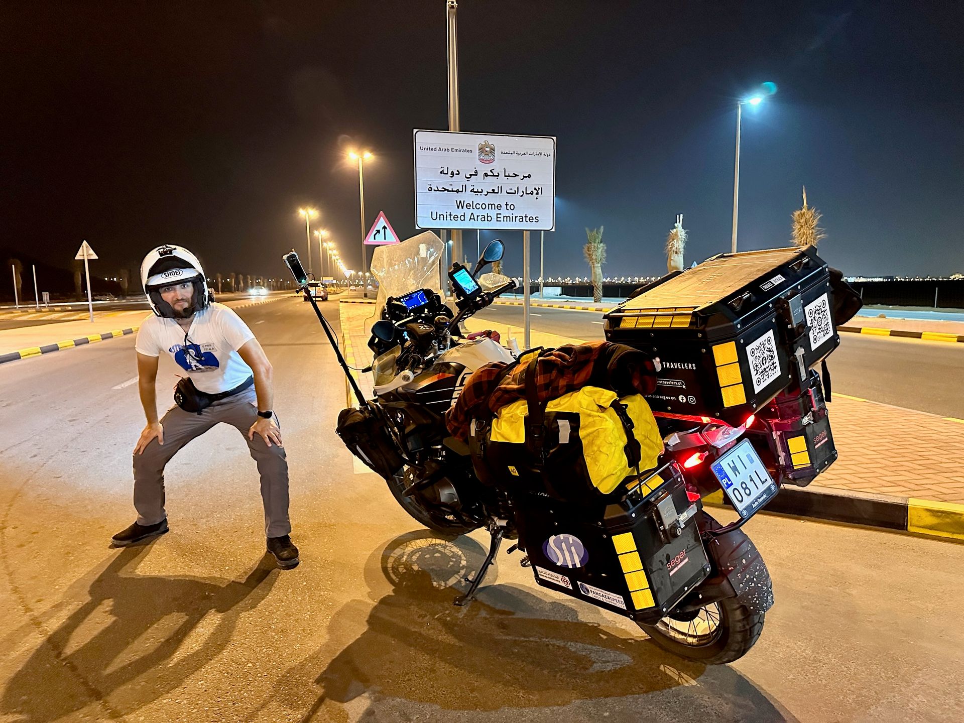 Motocyklista przy granicy lądowej al ktab z omanem w uae, obok znaku welcome to united arab emirates