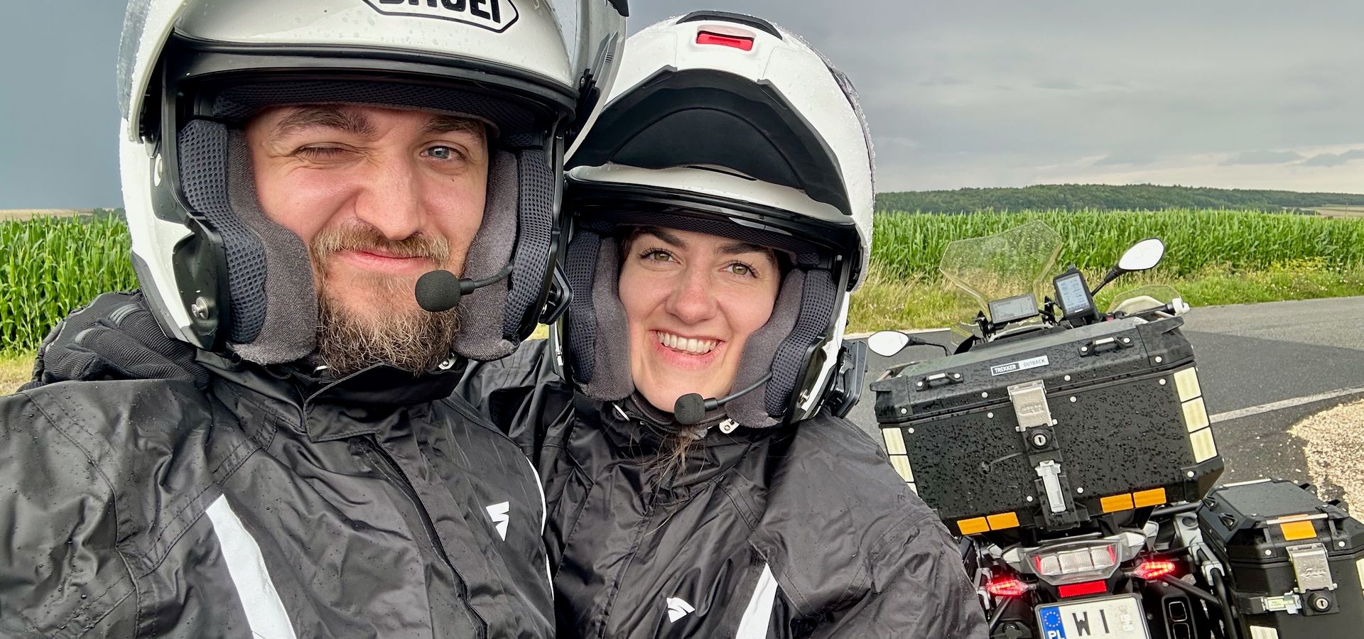 Jadzia i filip w kaskach pozują przy motocyklu na wiejskiej drodze pod warszawą.