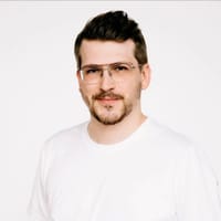 Portret mężczyzny w białej koszulce i okularach na jasnym tle