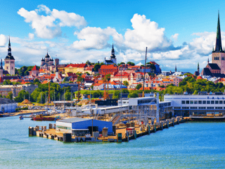 Panorama tallina z portem, kolorową starówką i wieżami kościołów pod błękitnym niebem