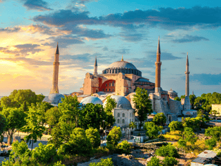 Hagia sophia w stambule o zachodzie słońca, z minaretami i kopułą nad zielonym parkiem