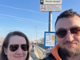 Dwie osoby na przystanku autobusowym vecsés-nyugat w słoneczny dzień.