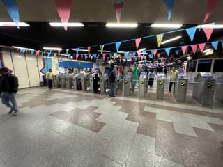 Egypt metro station ticket gates with passengers under colorful pennant flags