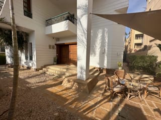 Livingville nine in cairo, egypt, showing a villa courtyard with patio seating and shade sails