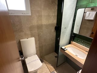 Bathroom in cairo livingville nine, egypt, with a toilet, sink, shower, and green tiled wall