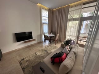 Living room at livingville nine in cairo, egypt, with a sofa, tv, and small dining table.