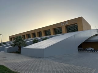 Dworzec kolejowy riyadh station w arabii saudyjskiej z podjazdem i palmami o zachodzie słońca