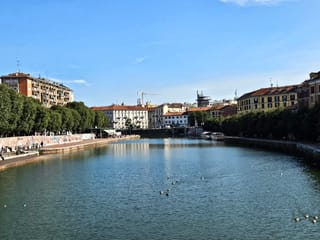 Naviglio grande w mediolanie z kanałem, drzewami i zabudową po obu stronach