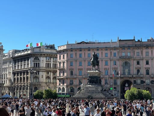 Piazza del duomo w mediolanie z pomnikiem i tłumem turystów