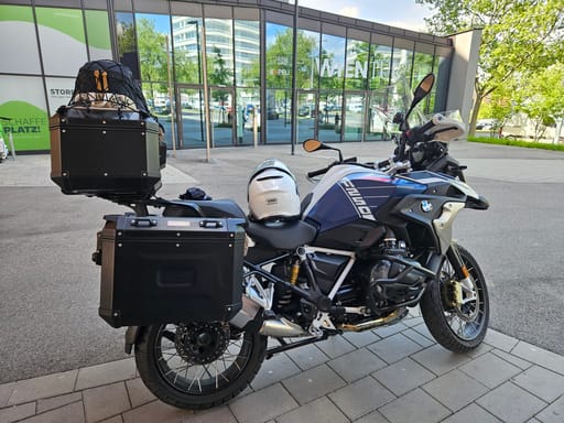 Motocykl bmw z kuframi zaparkowany przy nowoczesnym budynku w bratysławie.