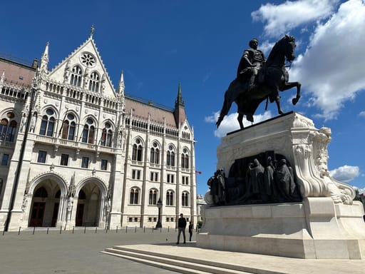 Budapeszt: pomnik i fasada gmachu parlamentu pod błękitnym niebem