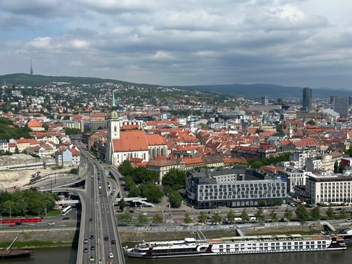 Panorama bratysławy z mostem nad dunajem, kościołem i czerwonymi dachami starego miasta