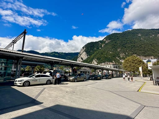 Dworzec w interlaken z peronami, taksówkami i górami w tle pod błękitnym niebem