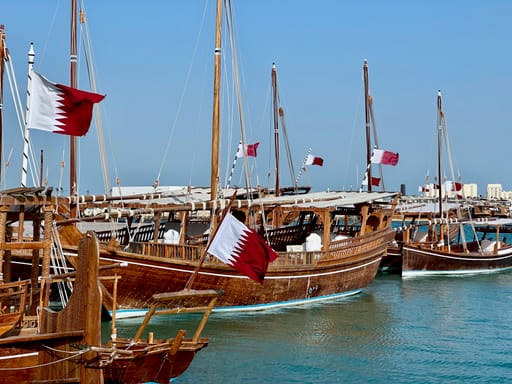 Łodzie dau z flagami kataru w porcie w doha