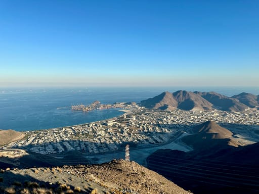 Widok na sharjah w zjednoczonych emiratach arabskich z wybrzeżem, portem i górami w tle