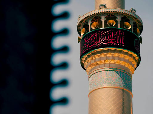 Ozdobny minaret w iraku z arabskimi napisami i głośnikami na szczycie
