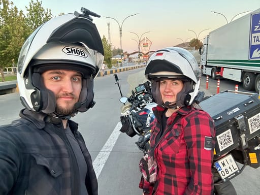 Dwoje motocyklistów w kaskach przy motocyklu, na ulicy w kurdystanie iraku o zmierzchu.