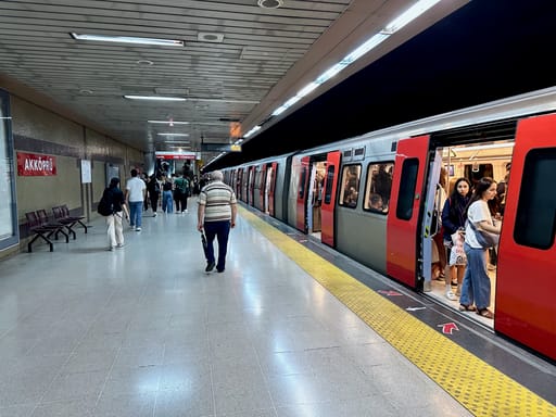 Peron stacji metra akköprü w ankarze z czekającym pociągiem i pasażerami