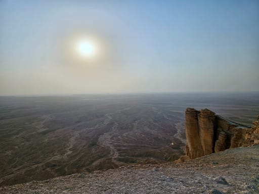 Klif edge of the world w arabii saudyjskiej z widokiem na rozległą pustynię skąpaną w słońcu