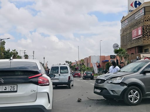 Wypadek drogowy w marrakeszu: dwa auta po kolizji na ulicy, z rozrzuconymi odłamkami na jezdni. Maroko