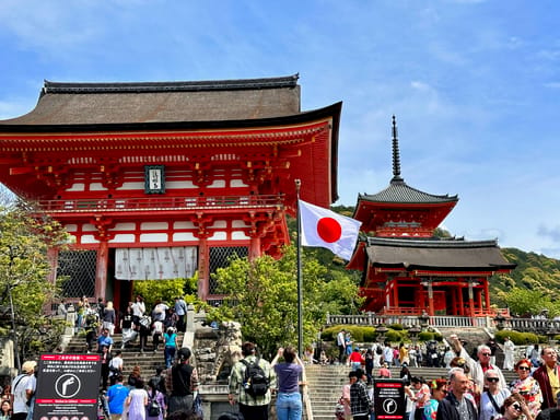 Kiyomizu-dera temple w kioto z tłumem turystów i japońską flagą
