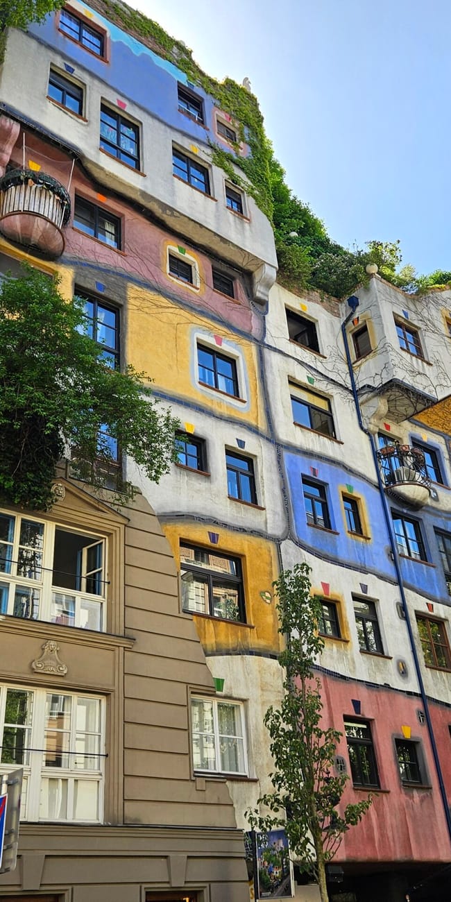 Hundertwasser house w wiedniu z kolorową, falującą fasadą i zielenią na dachu