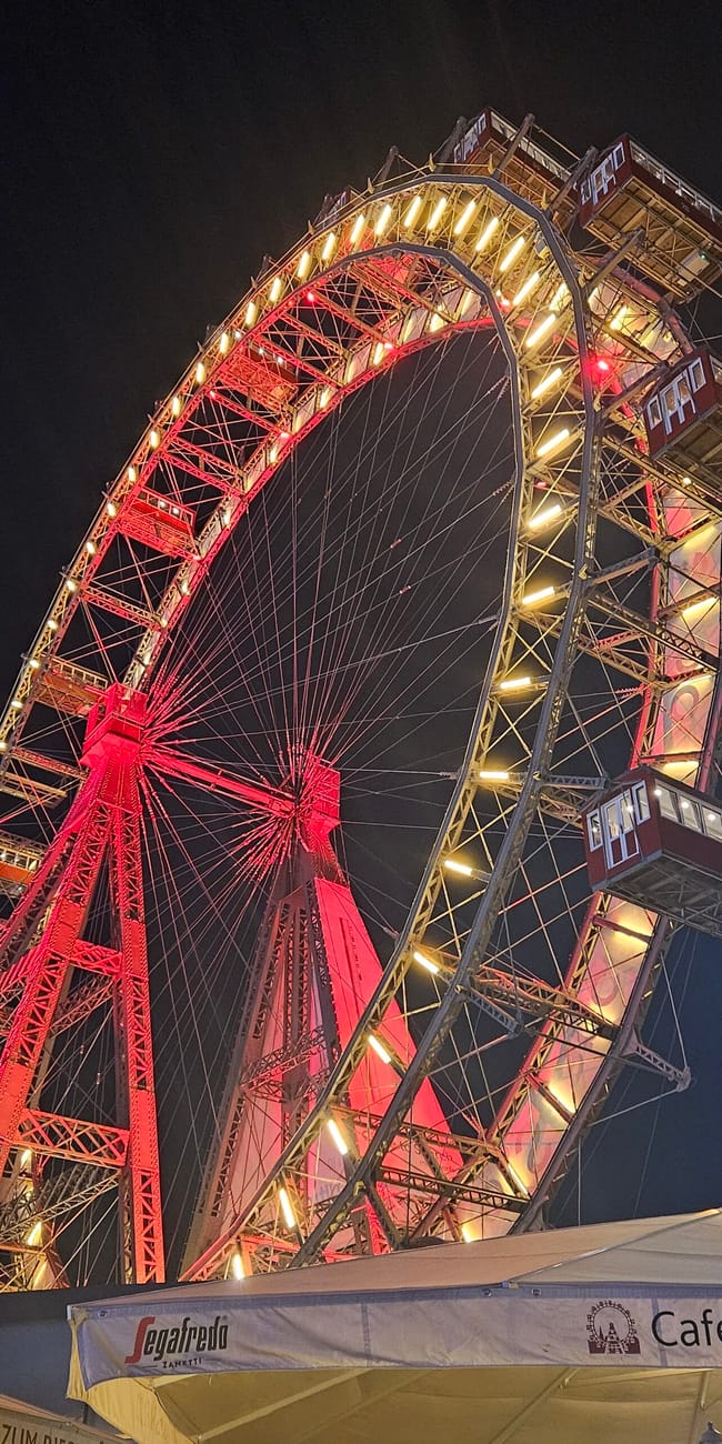 Diabelski młyn w vienna prater nocą, podświetlony na czerwono i żółto.