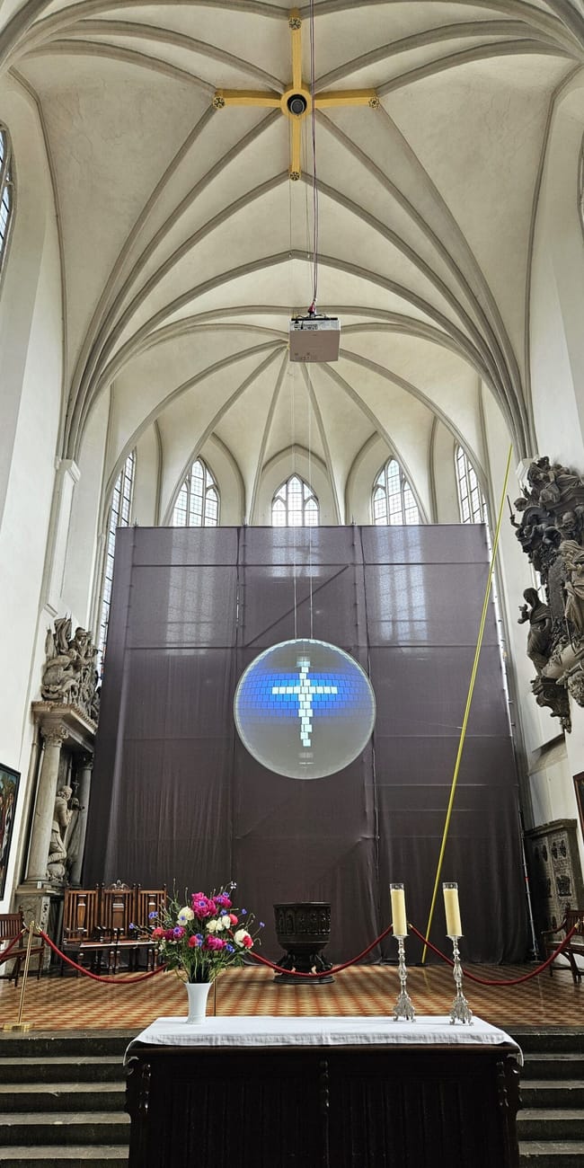 Wnętrze marienkirche w berlinie z gotyckim sklepieniem i ołtarzem z projekcją krzyża.