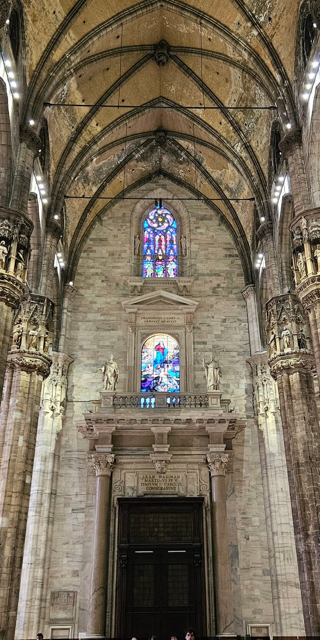 Wnętrze katedry duomo w mediolanie z gotyckimi filarami i witrażami