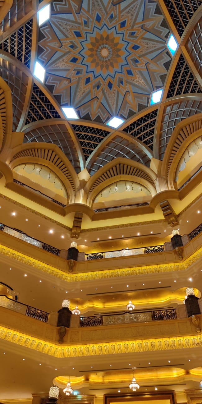 Wnętrze emirates palace w abu dhabi z bogato zdobionym kopułowym atrium.