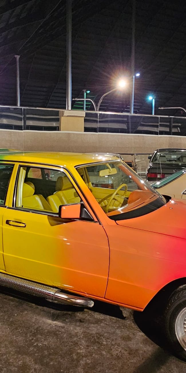 Uae, abu dhabi emirates national auto museum: colorful classic cars on display under bright lights at night