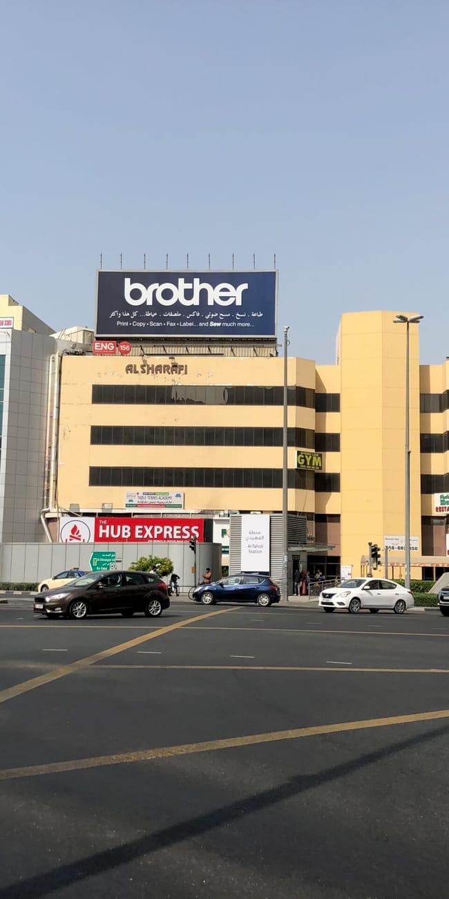Ulice dubaju z wieloma budynkami, billboardami i samochodami na skrzyżowaniu