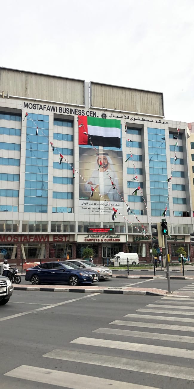 Mostafawi business centre w dubaju z flagą zea i przechodniami na przejściu dla pieszych