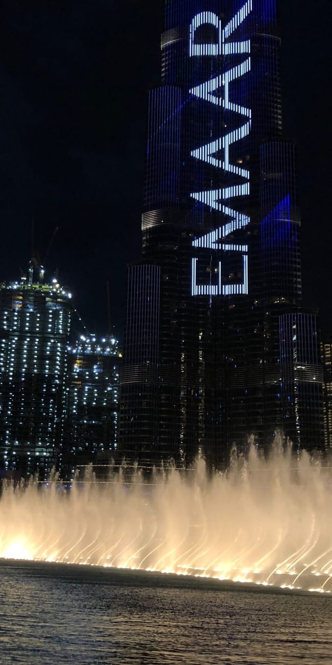 Dubai fountain z pokazem wody przed wieżowcem emaar w dubaju nocą