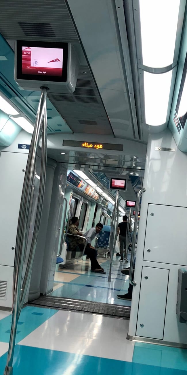 Wnętrze wagonu dubai metro z siedzeniami, uchwytami i pasażerami na pokładzie