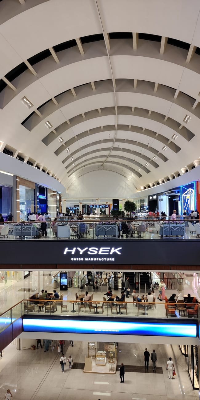 Dubai mall w dubaju, wielopoziomowe atrium z butikami i kawiarenkami