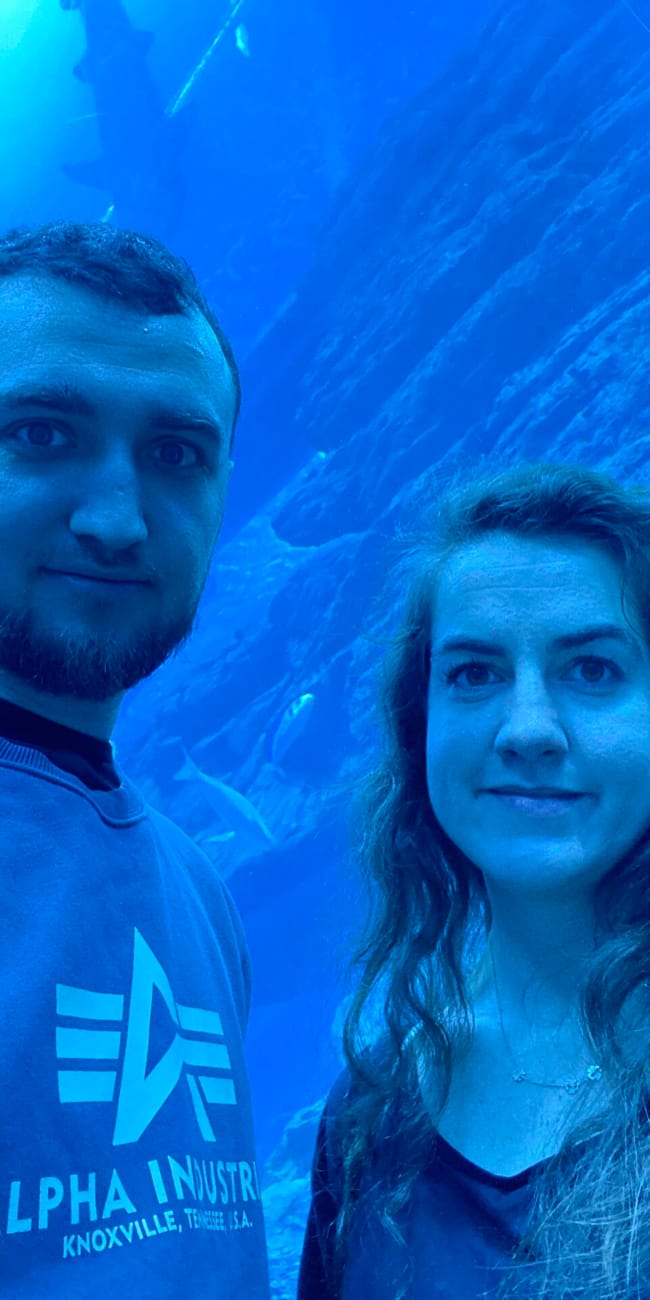 Dubai aquarium w dubaju, selfie dwojga osób na tle wielkiego akwarium z niebieskim światłem
