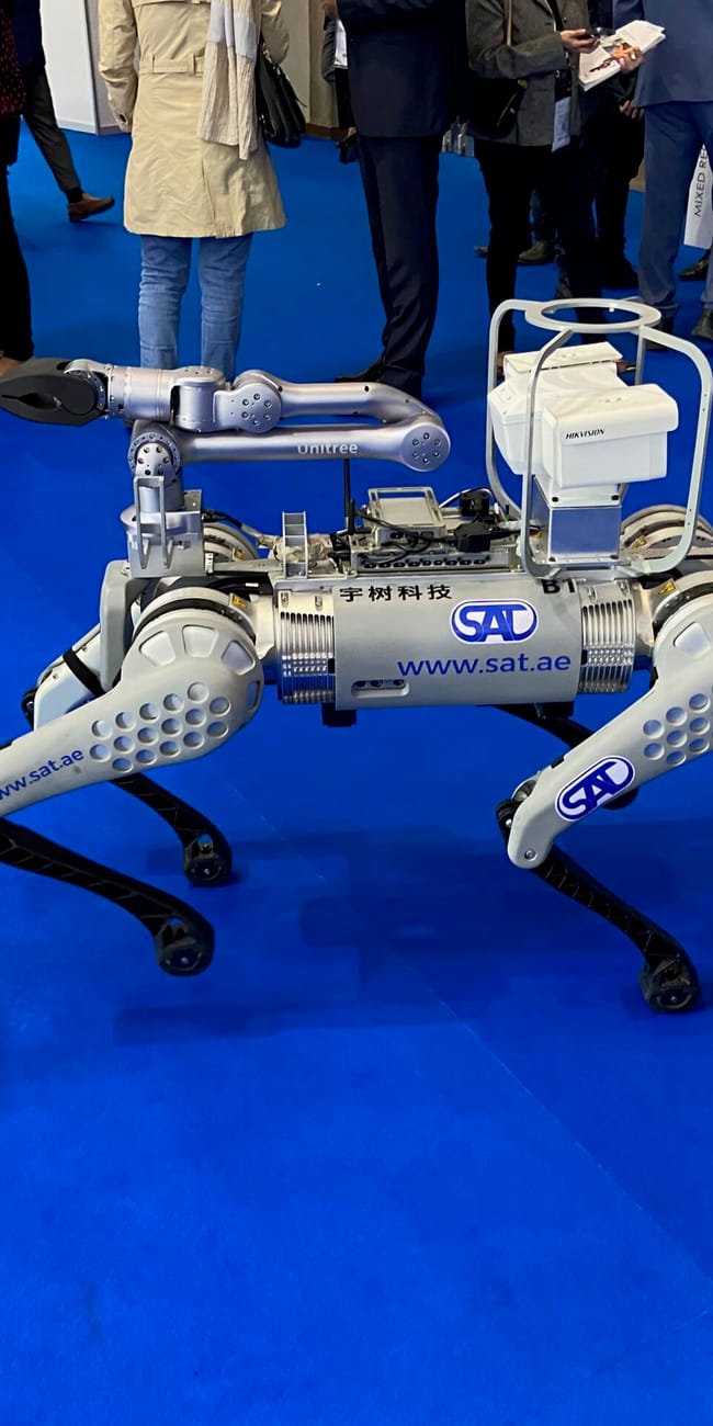 Robot kroczący na targach dubai intersec exhibition w dubaju, otoczony przez zwiedzających.