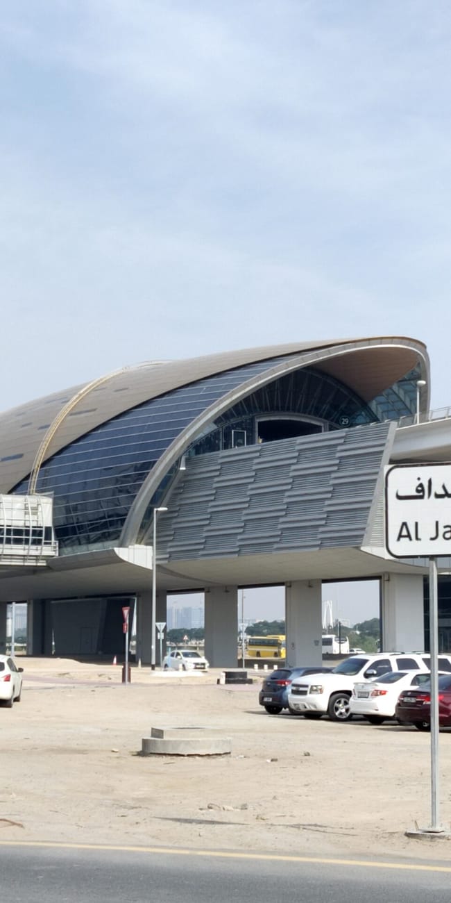 Stacja al jaddaf w dubaju z nowoczesnym budynkiem i parkingiem obok