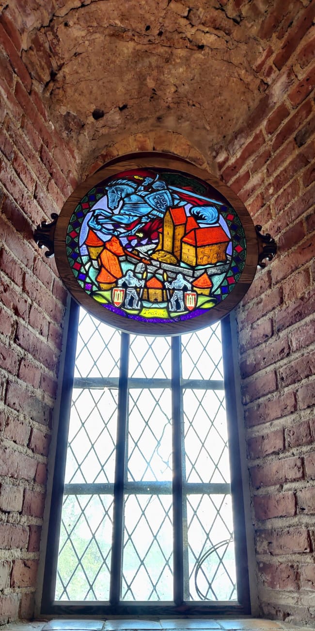 Witraż z zamkiem w trakai island castle w ceglanej wnęce okiennej
